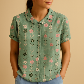 Vrouw draagt een luchtige blouse met vrolijke bloemenprint, ideaal voor zomerse dagen en casual outfits