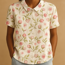 Vrouw draagt een luchtige blouse met vrolijke bloemenprint, ideaal voor zomerse dagen en casual outfits