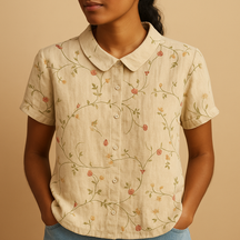 Vrouw draagt een luchtige blouse met vrolijke bloemenprint, ideaal voor zomerse dagen en casual outfits