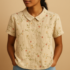 Vrouw draagt een luchtige blouse met vrolijke bloemenprint, ideaal voor zomerse dagen en casual outfits