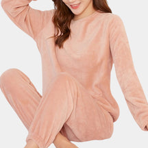 Comfortabele dames pyjamaset met zachte trui en broek in roze, perfect voor de nacht of een ontspannen avond thuis.