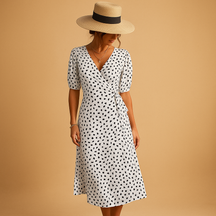 Zomerse V-hals jurk met speelse stippenprint voor dames. Luchtig en stijlvol voor casual dagen en zomerse feestjes.